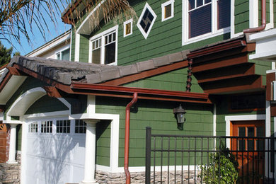 Ejemplo de fachada verde de estilo americano de tamaño medio de dos plantas con revestimiento de madera y tejado a dos aguas