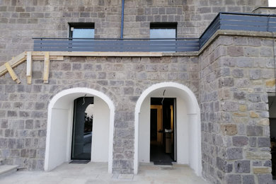 Ispirazione per la facciata di una casa mediterranea a due piani con rivestimento in pietra