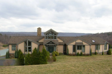 Example of a large arts and crafts beige two-story mixed siding exterior home design in Other