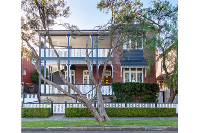 Trendy two-story brick house exterior photo in Sydney with a tile roof