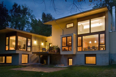 Large contemporary yellow three-story stucco exterior home idea in Kansas City
