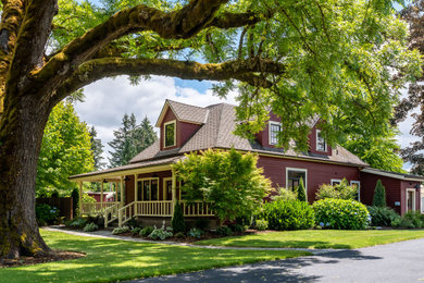 Inspiration for a mid-sized cottage red two-story wood and clapboard house exterior remodel in Portland with a hip roof, a shingle roof and a black roof