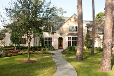 Large transitional beige two-story stone exterior home photo in Houston