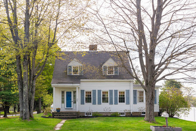 Imagen de fachada de casa blanca campestre de dos plantas con revestimiento de vinilo, tejado de teja de madera y tejado a dos aguas