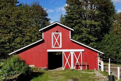 Cette photo montre une façade de maison rouge nature en bois de taille moyenne et de plain-pied avec un toit à deux pans et un toit en shingle.