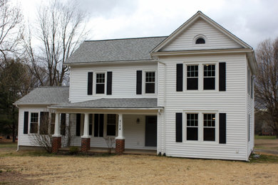 Foto de fachada de casa blanca tradicional de tamaño medio de dos plantas con revestimiento de vinilo, tejado a dos aguas y tejado de teja de madera