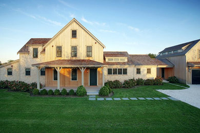 Inspiration for a large farmhouse beige two-story wood exterior home remodel in Boston with a shingle roof
