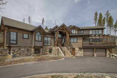 Example of a brown three-story stone exterior home design in Denver