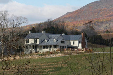 Diseño de fachada blanca de estilo de casa de campo grande de dos plantas con revestimiento de madera