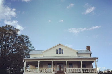 Immagine della facciata di una casa bianca country a due piani con rivestimento con lastre in cemento