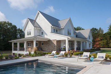 Großes, Zweistöckiges Landhausstil Einfamilienhaus mit Mix-Fassade, weißer Fassadenfarbe, Satteldach und Blechdach in Grand Rapids