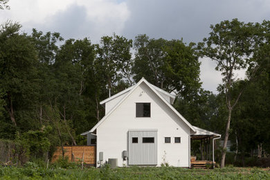 Ejemplo de fachada de estilo de casa de campo de dos plantas con tejado a dos aguas