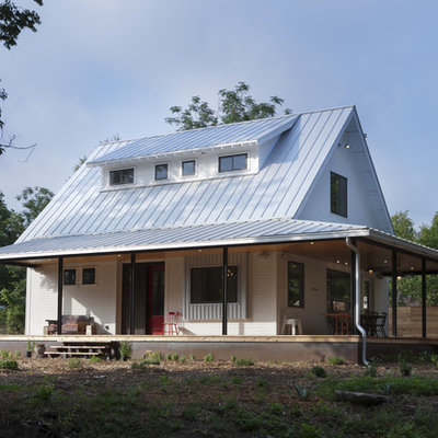 Example of a cottage wood exterior home design in Austin with a metal roof