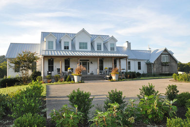Immagine della villa bianca rustica a due piani di medie dimensioni con rivestimento in legno, tetto a capanna e copertura in metallo o lamiera