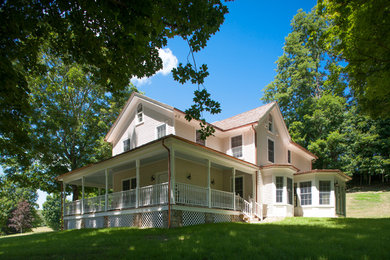 Mid-sized farmhouse beige two-story wood gable roof idea in New York