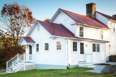 Immagine della facciata di una casa bianca country a due piani con rivestimento in legno