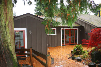 Imagen de fachada de casa marrón campestre de tamaño medio de una planta con revestimiento de madera, tejado a dos aguas y tejado de teja de madera