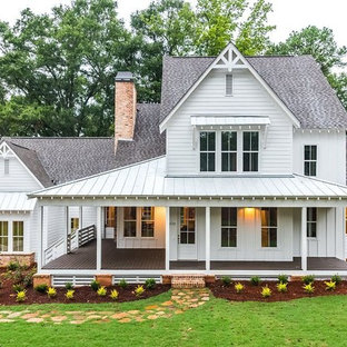 Exemple d'une grand façade de maison blanche nature à un étage avec un toit en shingle, un revêtement en vinyle et un toit à quatre pans.