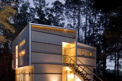 Ejemplo de fachada de casa beige moderna de tamaño medio de dos plantas con revestimientos combinados y tejado de un solo tendido