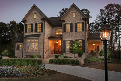 Inspiration for a large timeless beige two-story brick gable roof remodel in Atlanta