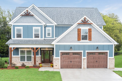 Diseño de fachada de casa azul tradicional de dos plantas con tejado a dos aguas y tejado de teja de madera