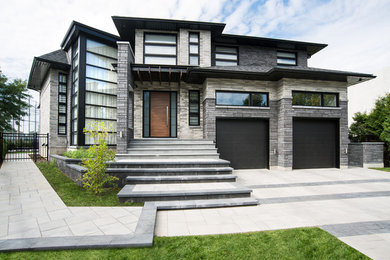 Réalisation d'une grande façade de maison grise design à un étage avec un revêtement mixte et un toit à deux pans.
