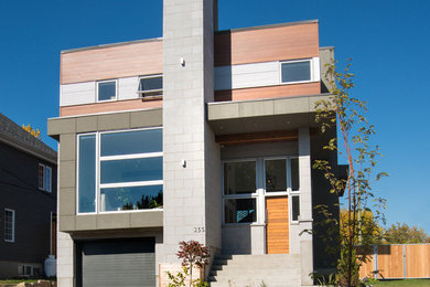 Mittelgroßes, Dreistöckiges Modernes Einfamilienhaus mit Mix-Fassade, grauer Fassadenfarbe und Flachdach in Montreal