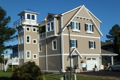 Large coastal gray three-story vinyl gable roof idea in Other