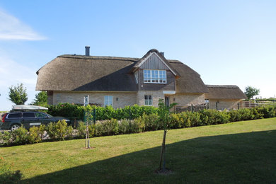 Foto de fachada de casa beige de estilo de casa de campo grande de dos plantas con revestimiento de ladrillo y tejado a la holandesa