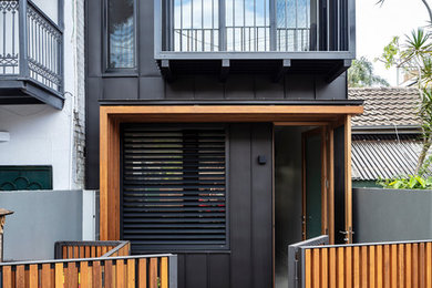 Mittelgroßes, Zweistöckiges Modernes Einfamilienhaus mit Metallfassade und schwarzer Fassadenfarbe in Sydney