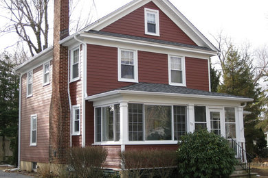 Ejemplo de fachada roja de tamaño medio de dos plantas con revestimiento de aglomerado de cemento y tejado a dos aguas