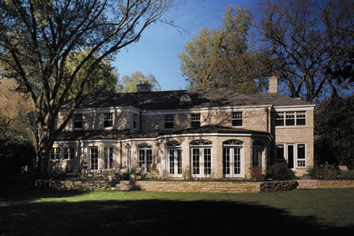 Foto de fachada clásica renovada de dos plantas con revestimiento de piedra y tejado a cuatro aguas