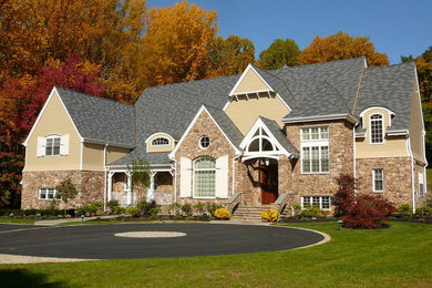 Modelo de fachada de casa beige clásica grande de dos plantas con revestimientos combinados, tejado a dos aguas y tejado de teja de madera