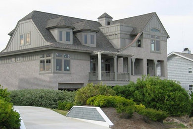 Imagen de fachada gris minimalista grande de tres plantas con revestimiento de madera y tejado a dos aguas