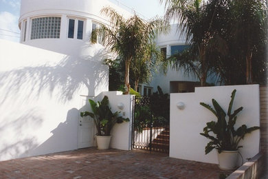 Imagen de fachada de casa blanca minimalista de tamaño medio de dos plantas con revestimiento de estuco y tejado plano