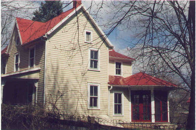 Cette image montre une façade de maison jaune traditionnelle en bois de taille moyenne et à un étage.