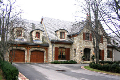 Esempio della facciata di una casa grande beige american style a due piani con rivestimento in pietra