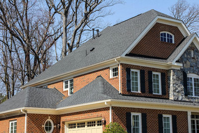 Large traditional red three-story brick house exterior idea in DC Metro with a clipped gable roof and a shingle roof