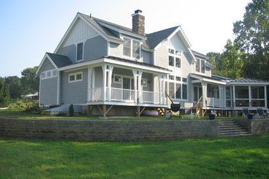 Example of a mid-sized beach style gray two-story house exterior design in New York with a shed roof