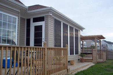 Example of a mid-sized transitional brown one-story vinyl house exterior design in Other with a hip roof and a shingle roof