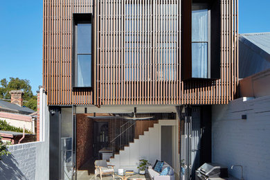 Идея дизайна: маленький, двухэтажный, деревянный, коричневый таунхаус в современном стиле с плоской крышей для на участке и в саду