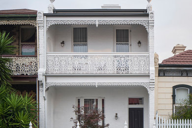 Modelo de fachada de casa blanca tradicional de tamaño medio de tres plantas con revestimiento de ladrillo, tejado a dos aguas y tejado de varios materiales
