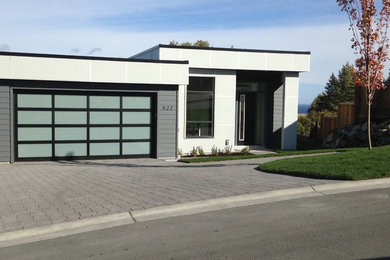 This is an example of a medium sized and gey contemporary bungalow concrete detached house in Vancouver with a flat roof.