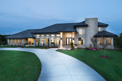 Inspiration for a large contemporary beige two-story stucco exterior home remodel in Wichita with a hip roof