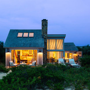 Aménagement d'une façade de maison beige bord de mer de taille moyenne et à un étage avec un revêtement en vinyle et un toit à deux pans.