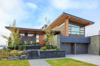 Diseño de fachada de casa multicolor actual grande de dos plantas con revestimiento de madera y tejado de un solo tendido