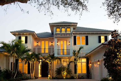 Large coastal white two-story stucco exterior home idea in Miami with a hip roof