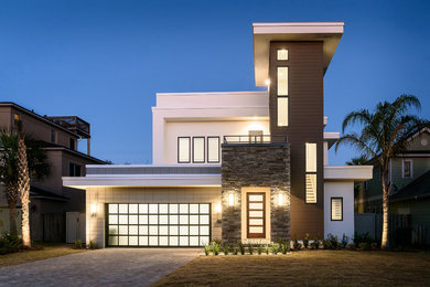 Ejemplo de fachada de casa multicolor actual grande de dos plantas con tejado plano, revestimientos combinados y techo verde
