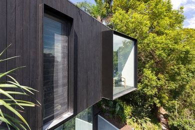 Свежая идея для дизайна: большой, трехэтажный, деревянный, черный частный загородный дом в современном стиле с плоской крышей и зеленой крышей - отличное фото интерьера
