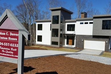 Diseño de fachada multicolor moderna grande de tres plantas con revestimiento de estuco y tejado plano